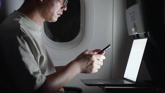 男子在飞机上用手机刷视频