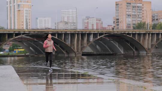 女人沿着河岸慢跑