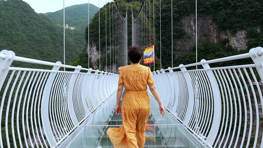 4K升格实拍在玻璃栈道吊桥上游览的东方女性
