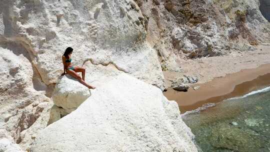 模特坐在白色岩石上