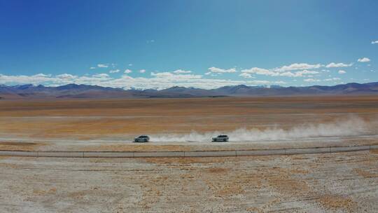 航拍越野车行驶在西藏无人区辽阔的草原上