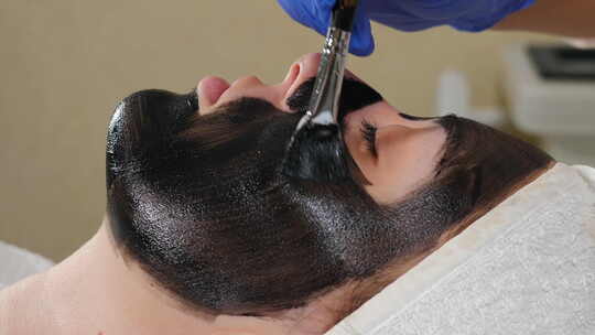 美容诊所美容程序的准备。美容医生在皮肤上应用碳化合物视频素材模板下载