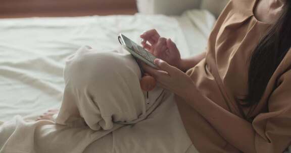 女性卧室中使用智能手机