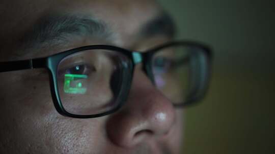 戴眼镜的男子晚上加班在电脑前工作视频素材模板下载