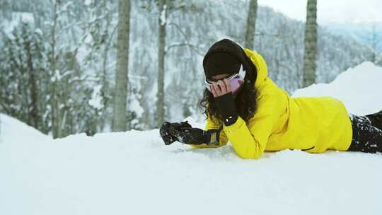 戴着手套躺在雪地上的女人