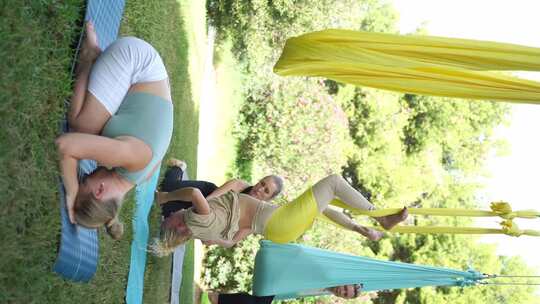 女性在公共公园户外一起锻炼瑜伽和吊床伸展视频素材模板下载