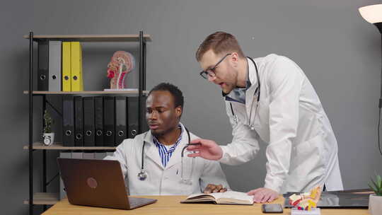 两名医生在诊所检查笔记本电脑屏幕