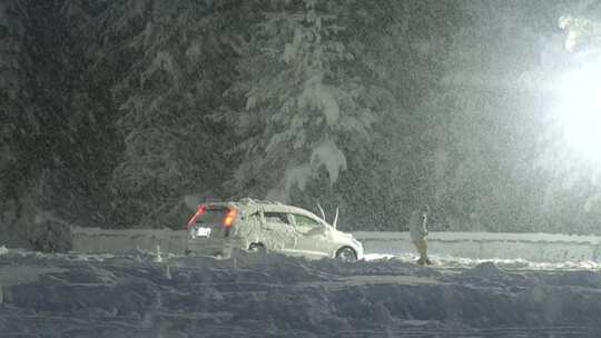 暴雪天气男子清理汽车周边的积雪视频素材模板下载
