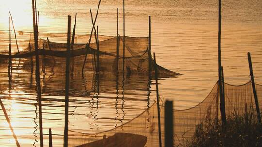夕阳下河边的小渔村渔网