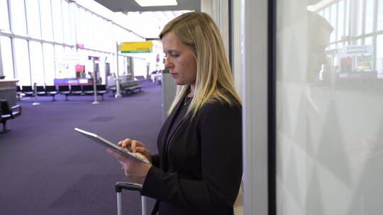 商务女性在机场使用数字平板电脑