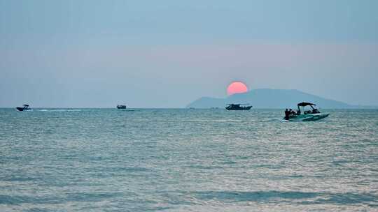 海南三亚湾海水浴场傍晚夕阳海上船只