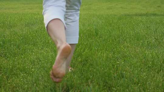 赤脚奔跑在绿色的草地上