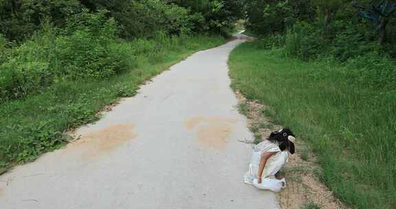 可爱小女孩在山间偏僻小路捡路边的美丽矿石