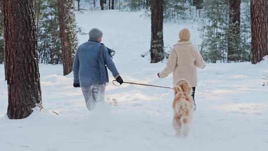 冬天，一男一女，一对年轻夫妇带着狗跑过白