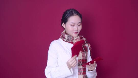 喜庆穿着的年轻女性拿着红包