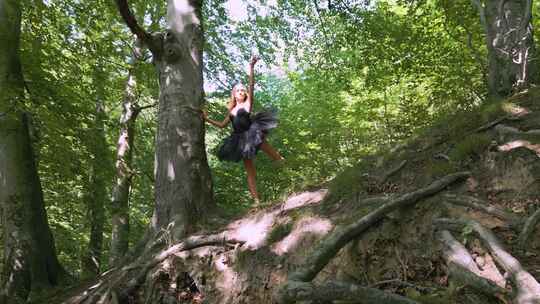 穿着黑色短裙的芭蕾舞演员在郁郁葱葱的森林