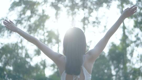 女孩在树林向天空阳光挥手视频素材