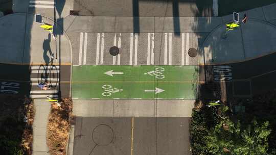 骑自行车的人通过使用自行车道的空置十字路口的自上而下的视图。