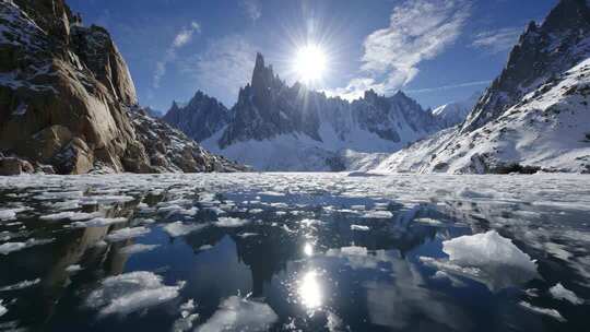 雪山下结冰湖面阳光景象
