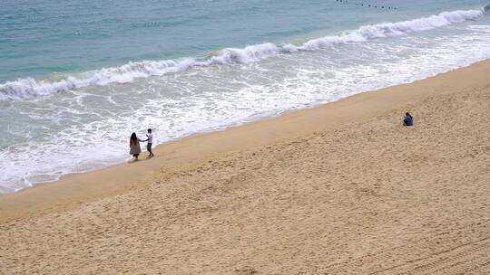 深圳大梅沙海滩情侣游客一人静坐沙滩上