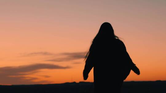 黄昏夕阳下西北戈壁滩行走的少女背影