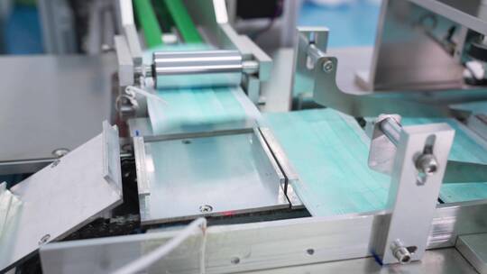 工厂机器正在争相生产口罩医用三层蓝色