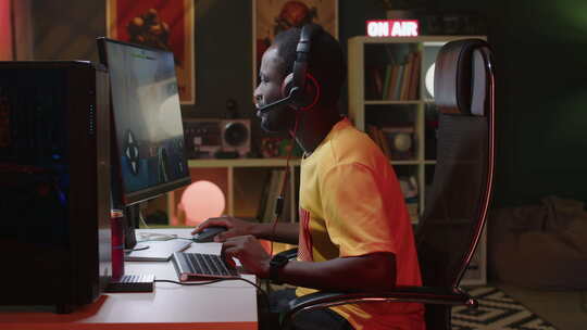 年轻的男性玩家在电脑上玩射手视频游戏