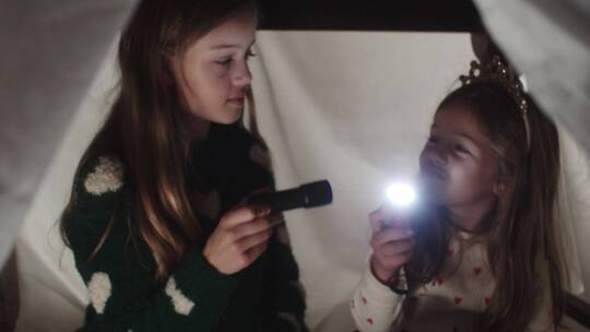 女孩在露营敞篷里玩手电筒视频素材模板下载