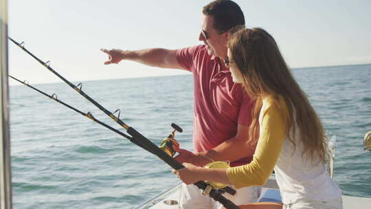 一名白人男子和他十几岁的女儿在船上钓鱼的侧视图