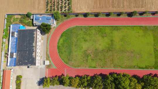 航拍坐落于田地里的乡村中学全景