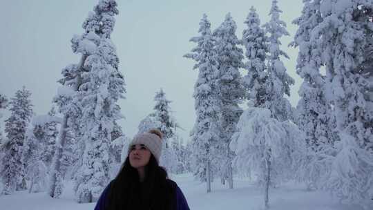 美丽的女孩在芬兰北极圈拉普兰的雪林中探索