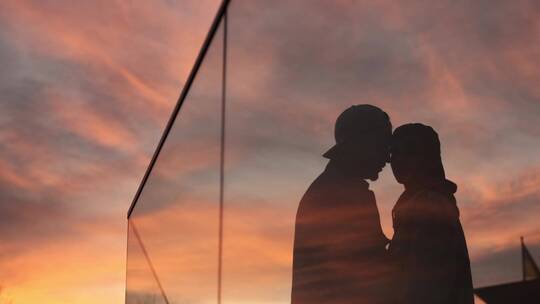 情侣亲吻倒影在建筑玻璃上视频素材模板下载