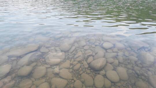 鹅卵石清澈水面随微风缓缓流淌背景