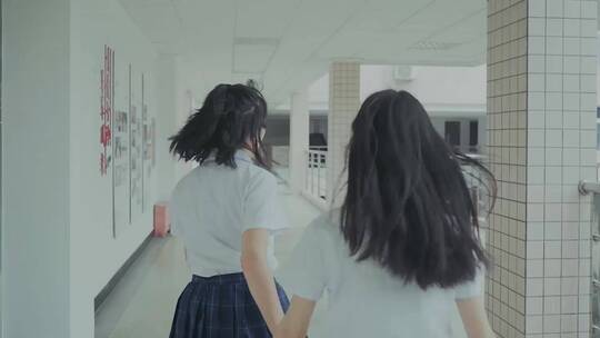 两个女孩在校园里奔跑