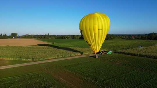 亮黄色热气球在野外飞行的鸟瞰图