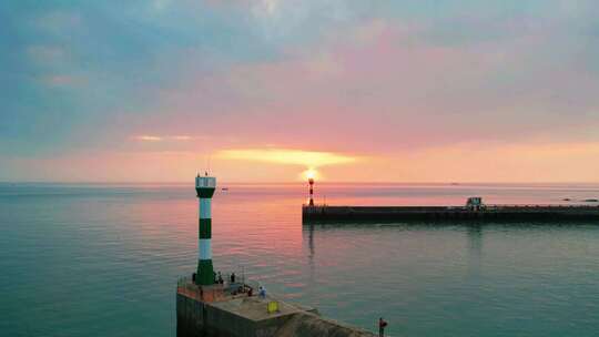 海上夕阳下的灯塔，急速快艇行驶回港口码头