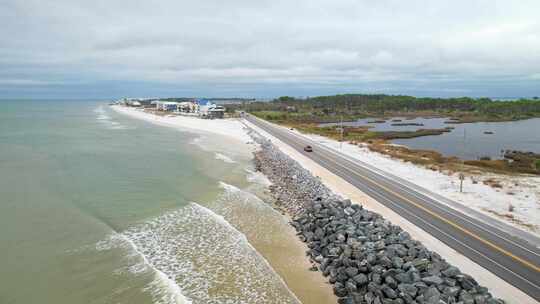 佛罗里达州圣布拉斯角，海浪撞击岩石屏障，空中拉离公路