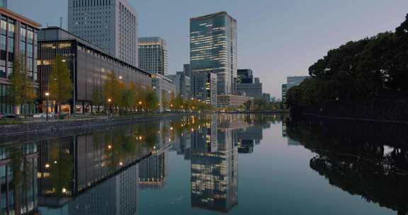 日落时分，城市里的汽车和建筑倒映在水面上