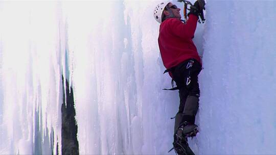 男人爬上冰冻瀑布的特写视频素材模板下载