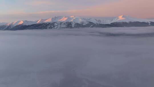 航拍冬季清晨的新疆喀纳斯雪景和日照金山