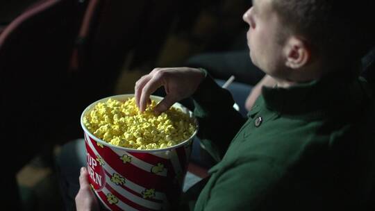 男人在电影院吃爆米花视频素材模板下载