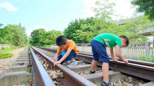 小孩走在铁路上玩耍