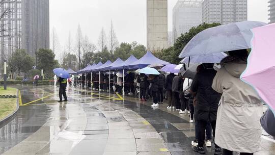 下雨天市民排队在城市广场上做核酸