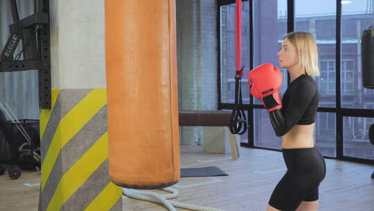 女人在健身房打沙袋练习拳击视频素材模板下载