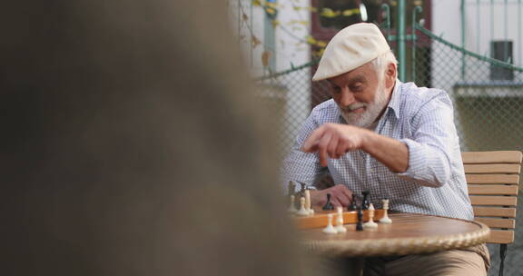 退休老人围着桌子下国际象棋 