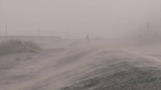新疆沙尘天气 车辆经过时的坡道公路风沙