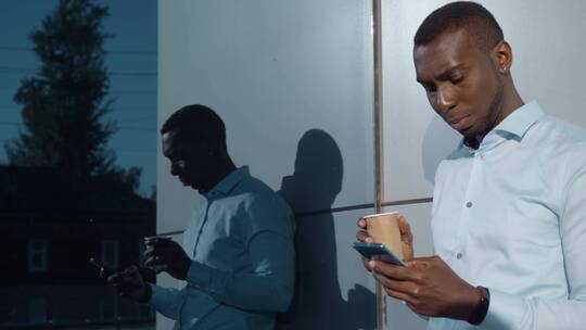 男人端着咖啡玩手机视频素材模板下载