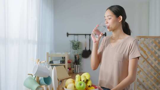 女人在家厨房喝一杯水视频素材模板下载