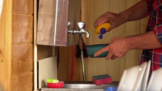 男人在乡村别墅的厨房水槽里洗碗