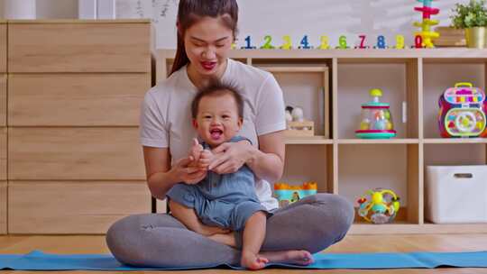 亚洲妈妈做瑜伽运动平衡身体与可爱的婴儿婴